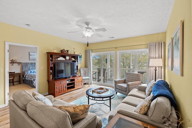 living room featuring ceiling fan and light hardwood / wood-style floors