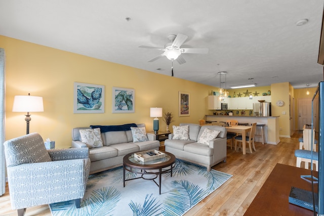 living room featuring ceiling fan and light wood-type flooring