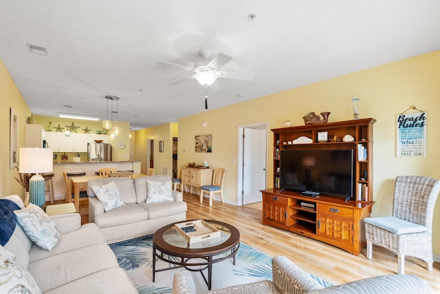 living room with light hardwood / wood-style flooring and ceiling fan