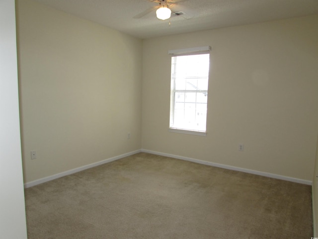 spare room featuring light carpet and ceiling fan