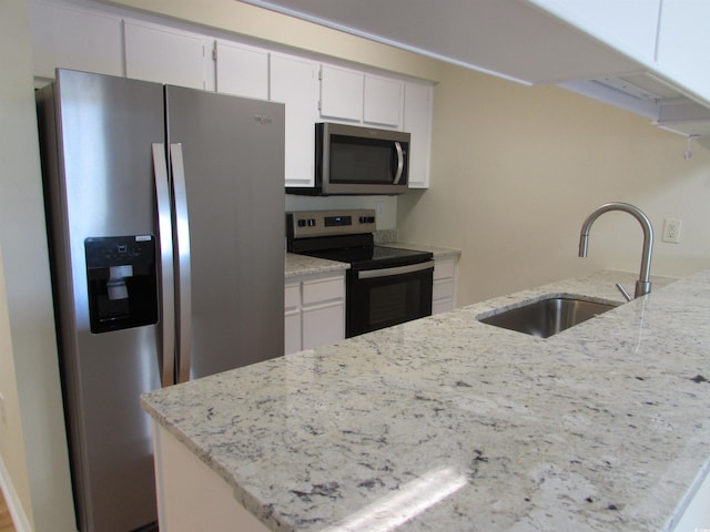 kitchen featuring sink, appliances with stainless steel finishes, light stone counters, and white cabinets