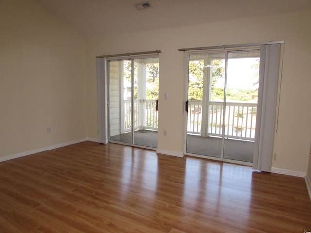 unfurnished room featuring lofted ceiling and hardwood / wood-style flooring