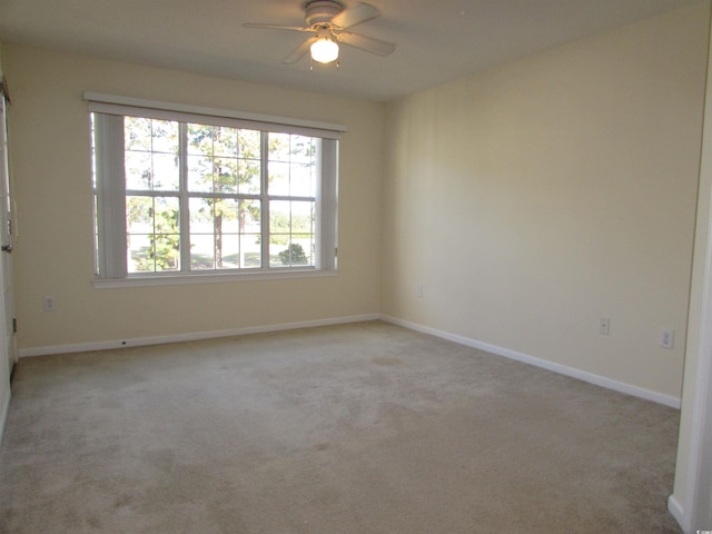 carpeted spare room featuring ceiling fan