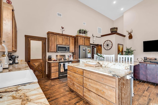 7299 Cartrette Rd, Aynor, SC 29511 - kitchen featuring stainless steel appliances, high vaulted ceiling, dark wood-style flooring, a center island, and a breakfast bar area