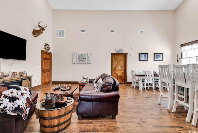 living room featuring a high ceiling and hardwood / wood-style flooring