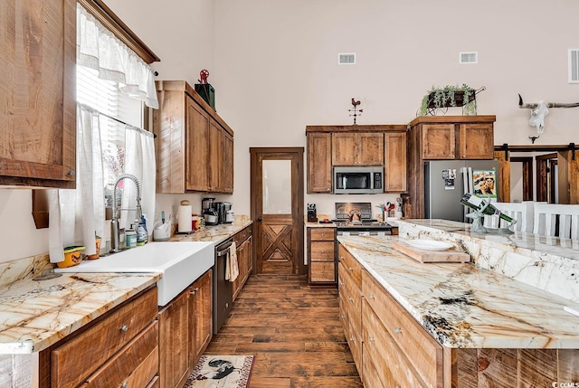 7299 Cartrette Rd, Aynor, SC 29511 - kitchen with appliances with stainless steel finishes, a sink, dark wood-type flooring, a towering ceiling, and brown cabinets