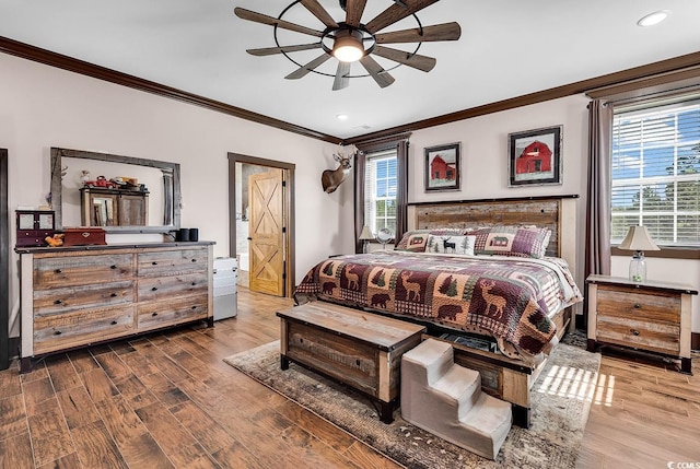 bedroom featuring ceiling fan, crown molding, multiple windows, and hardwood / wood-style flooring