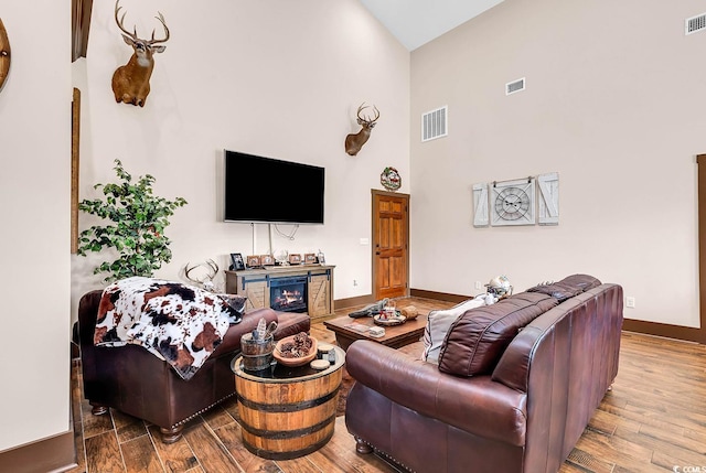7299 Cartrette Rd, Aynor, SC 29511 - living room with wood finished floors, a high ceiling, baseboards, and a warm lit fireplace