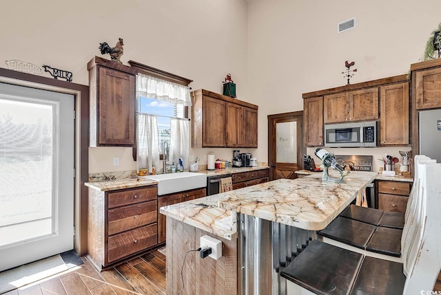 7299 Cartrette Rd, Aynor, SC 29511 - kitchen with stainless steel microwave, a towering ceiling, a sink, a kitchen island, and a kitchen breakfast bar