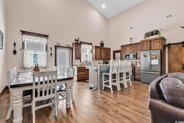 7299 Cartrette Rd, Aynor, SC 29511 - dining space with a towering ceiling, a barn door, and wood finished floors