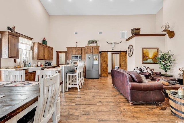 living room featuring a barn door and light wood-type flooring