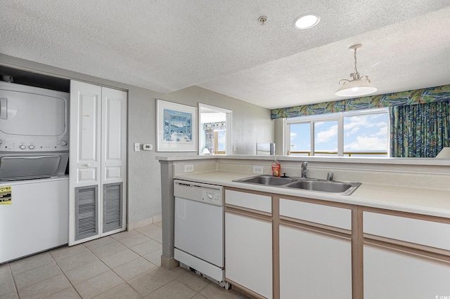 kitchen with pendant lighting, sink, stacked washer / drying machine, white cabinets, and dishwasher