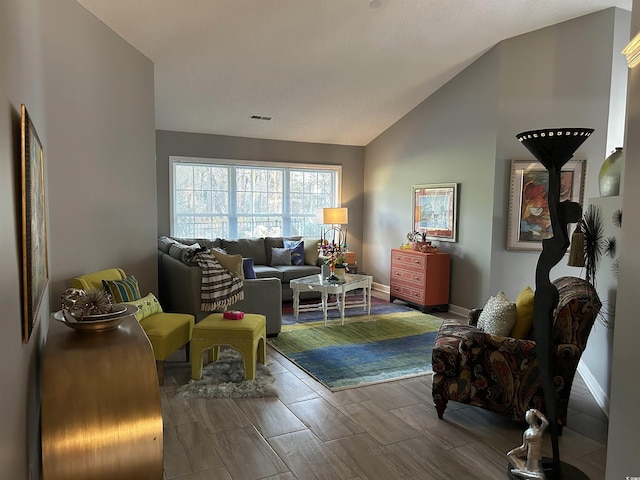 sitting room featuring lofted ceiling, visible vents, baseboards, and wood tiled floor