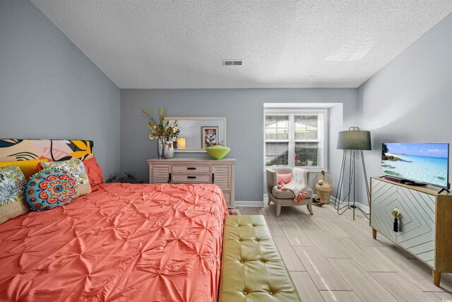 bedroom featuring light wood-type flooring and a textured ceiling