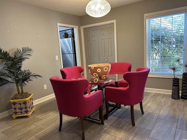 dining room featuring a healthy amount of sunlight, wood tiled floor, and baseboards