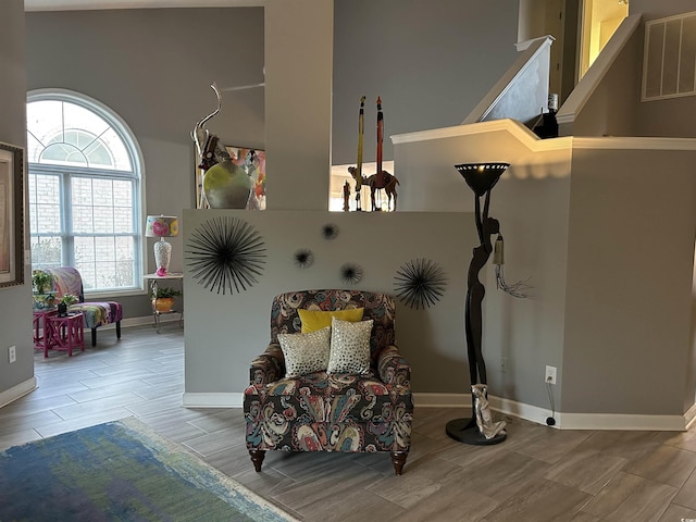 living area featuring wood tiled floor, visible vents, and baseboards