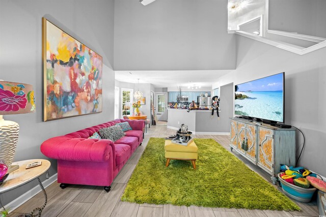 living room featuring light hardwood / wood-style flooring and a high ceiling