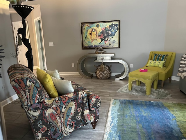 living area with baseboards and wood finished floors