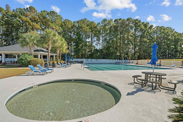 community pool featuring fence and a patio