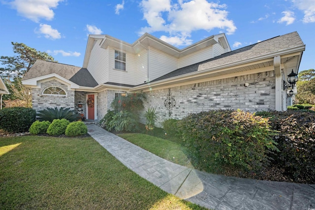 view of front of house featuring a front yard and brick siding