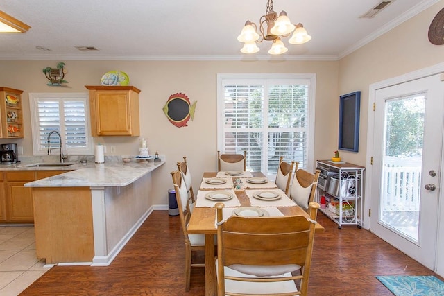 dining space with dark wood-type flooring, plenty of natural light, sink, and ornamental molding