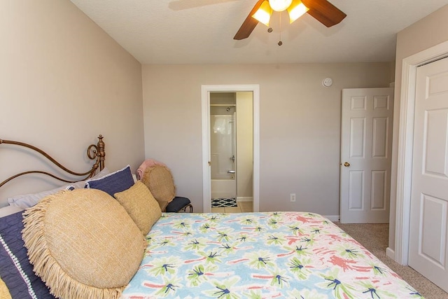 carpeted bedroom with ensuite bathroom, ceiling fan, and a textured ceiling