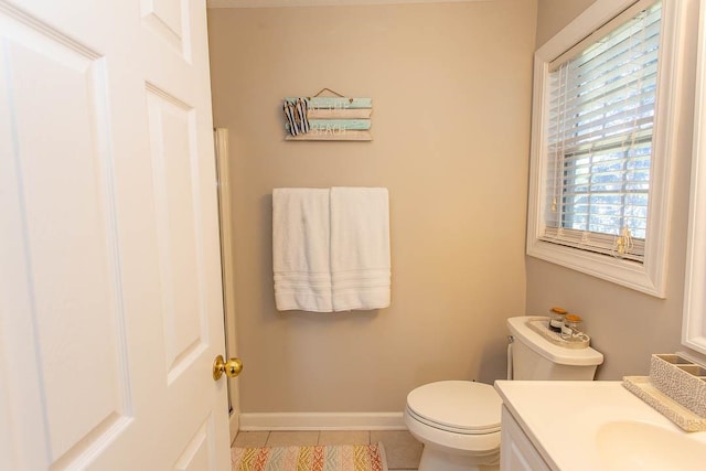 bathroom featuring toilet, vanity, a wealth of natural light, and tile patterned floors