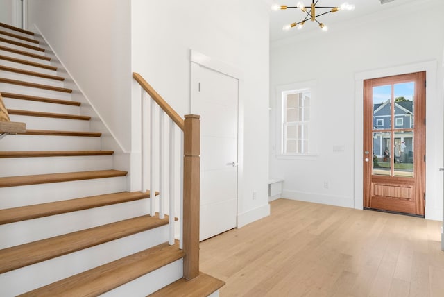 entrance foyer with light hardwood / wood-style flooring and a notable chandelier