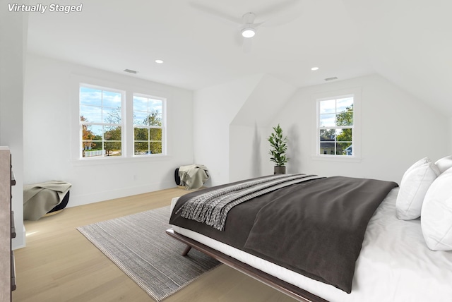 bedroom with light wood-type flooring, multiple windows, lofted ceiling, and ceiling fan