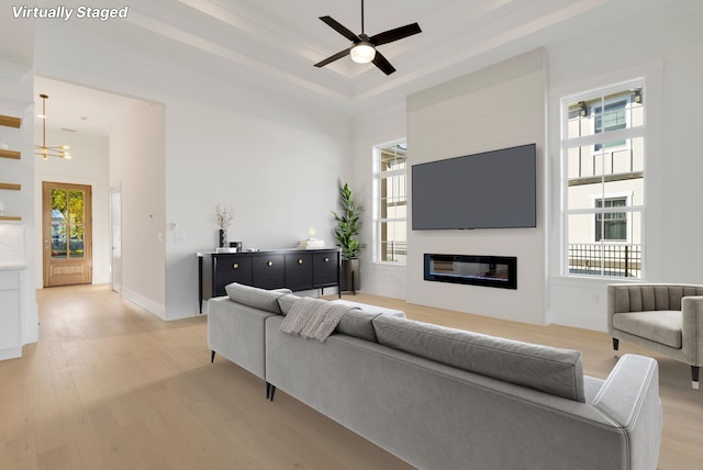 living room with light hardwood / wood-style flooring, a high ceiling, and plenty of natural light