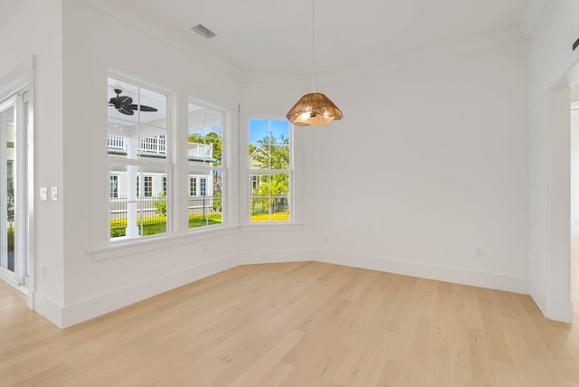 spare room with ceiling fan, light wood-type flooring, and ornamental molding