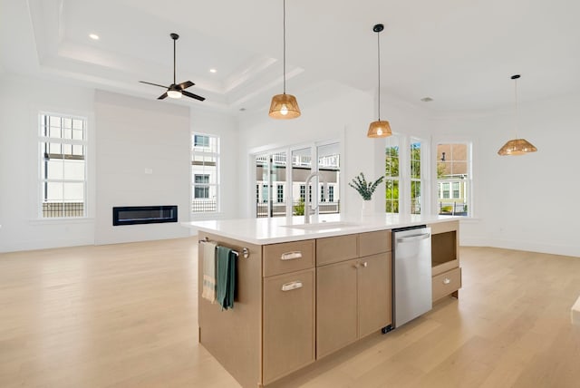 kitchen with an island with sink, light hardwood / wood-style floors, sink, and dishwasher