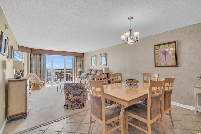 dining space with an inviting chandelier, a textured ceiling, and light tile patterned floors