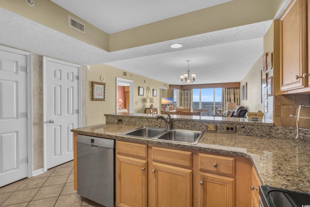 kitchen with appliances with stainless steel finishes, a textured ceiling, light tile patterned floors, sink, and a chandelier