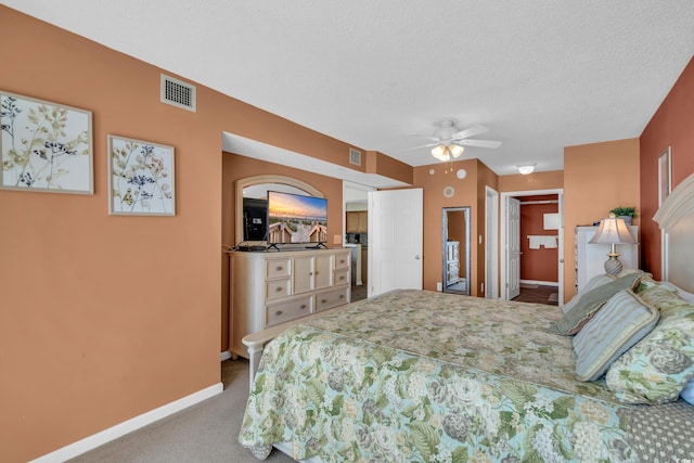 carpeted bedroom featuring a textured ceiling and ceiling fan