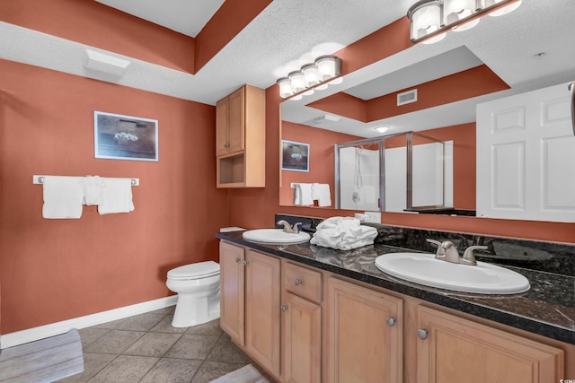 bathroom featuring tile patterned flooring, a textured ceiling, vanity, an enclosed shower, and toilet