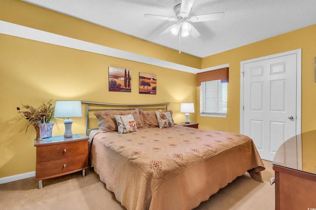 carpeted bedroom featuring a textured ceiling and ceiling fan