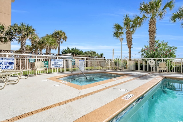 view of swimming pool with a hot tub