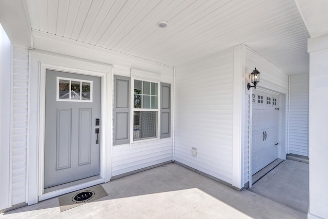 doorway to property featuring a garage and covered porch