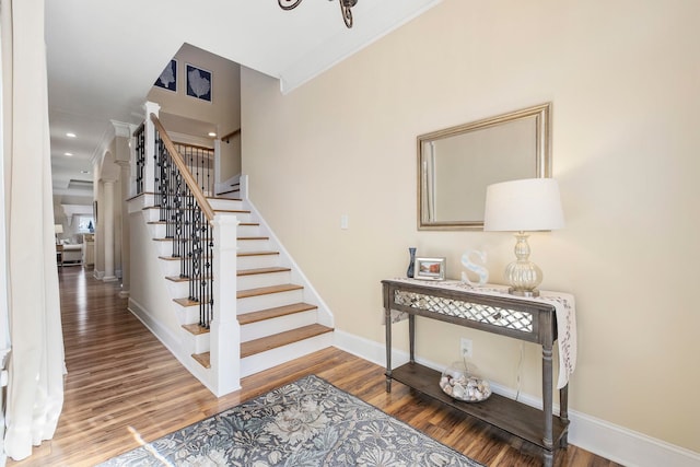 stairway with crown molding and hardwood / wood-style flooring