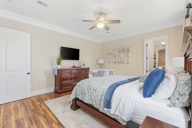 bedroom featuring ceiling fan, ornamental molding, ensuite bathroom, and hardwood / wood-style floors