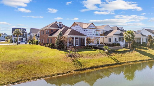 rear view of property with a yard and a water view