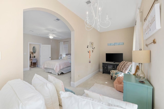 carpeted bedroom featuring ceiling fan with notable chandelier