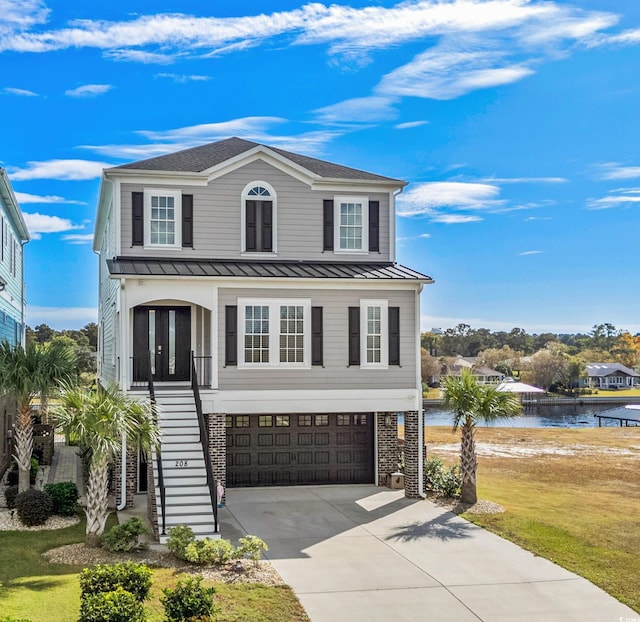 view of front of home featuring a garage, a water view, and a front yard