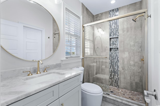 bathroom featuring walk in shower, vanity, and toilet