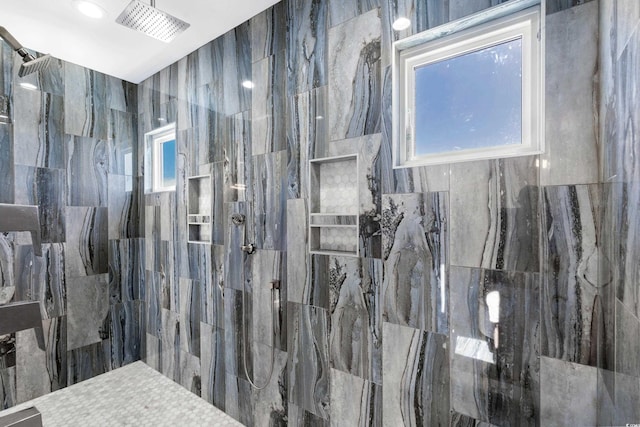 bathroom featuring tile walls and a tile shower