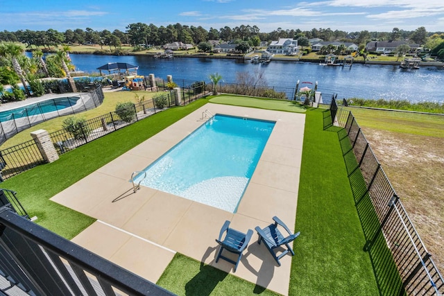 view of swimming pool featuring a patio, a water view, and a lawn