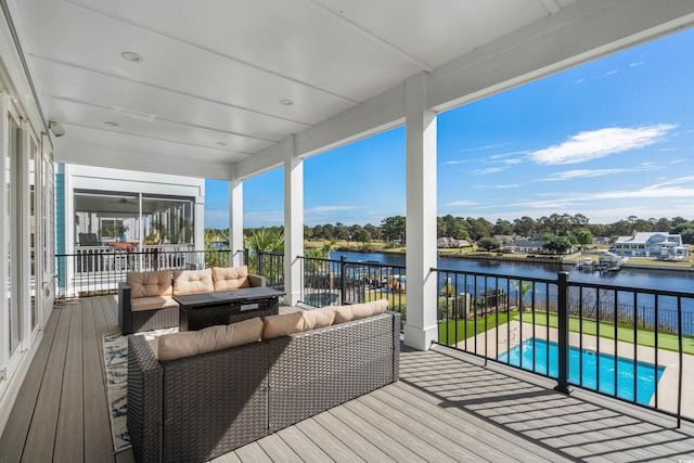 deck featuring outdoor lounge area, a fenced in pool, and a water view