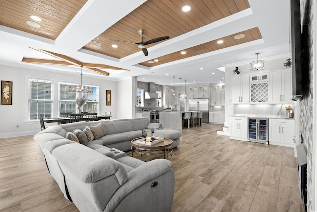 living room with wooden ceiling, light hardwood / wood-style floors, wine cooler, ceiling fan with notable chandelier, and crown molding