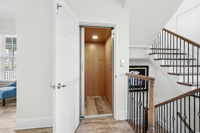 staircase with elevator and wood-type flooring